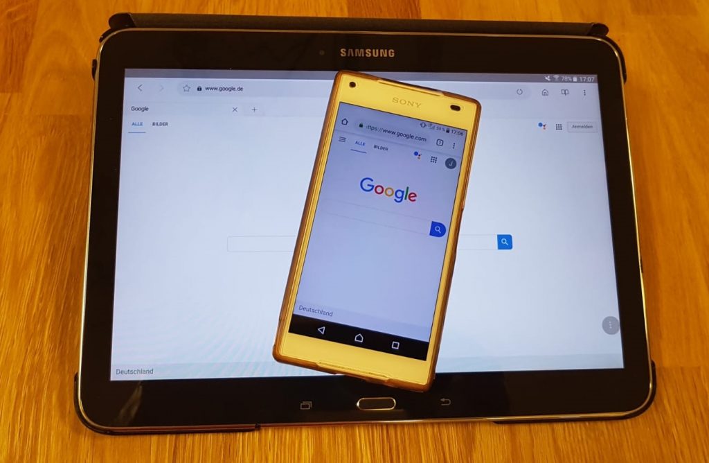 Ein Smartphone, das die Google-Suchansicht zeigt und auf einem Tablet liegt